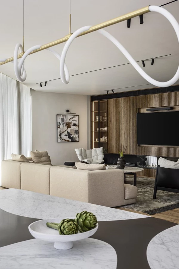 במרכז שולחן פיסולי-מוזאלי שמורכב ממשטח קוריאן בשני גוונים ורגל דומיננטית מחופה בעור