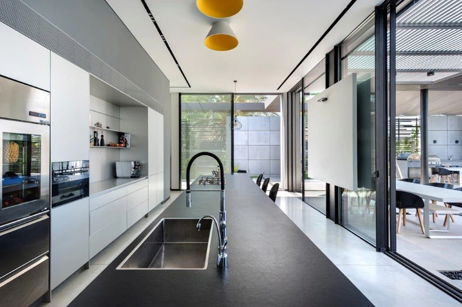 ביציאה מהמטבח ממוקמים פינת אוכל החיצונית, מטבח חוץ גדול ומאובזר ובהמשך  Pool House בו מלתחות וחדר רחצה. צילום: עודד סמדר | אדריכלים: דן והילה ישראלביץ