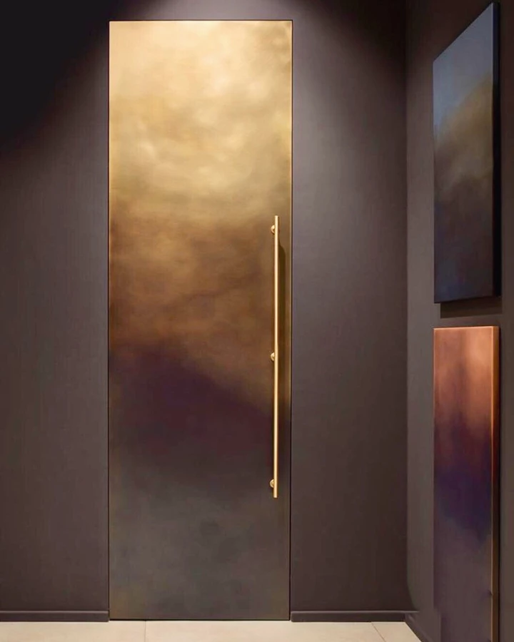 דלת פנים בקו אפס, מיוצרת מזכוכית עם מסגרת פליז מחולקת, המתכתבת עם סגנון דלת הכניסה, תוך שמירה על שפה עיצובית אחידה בחללי הבית השונים