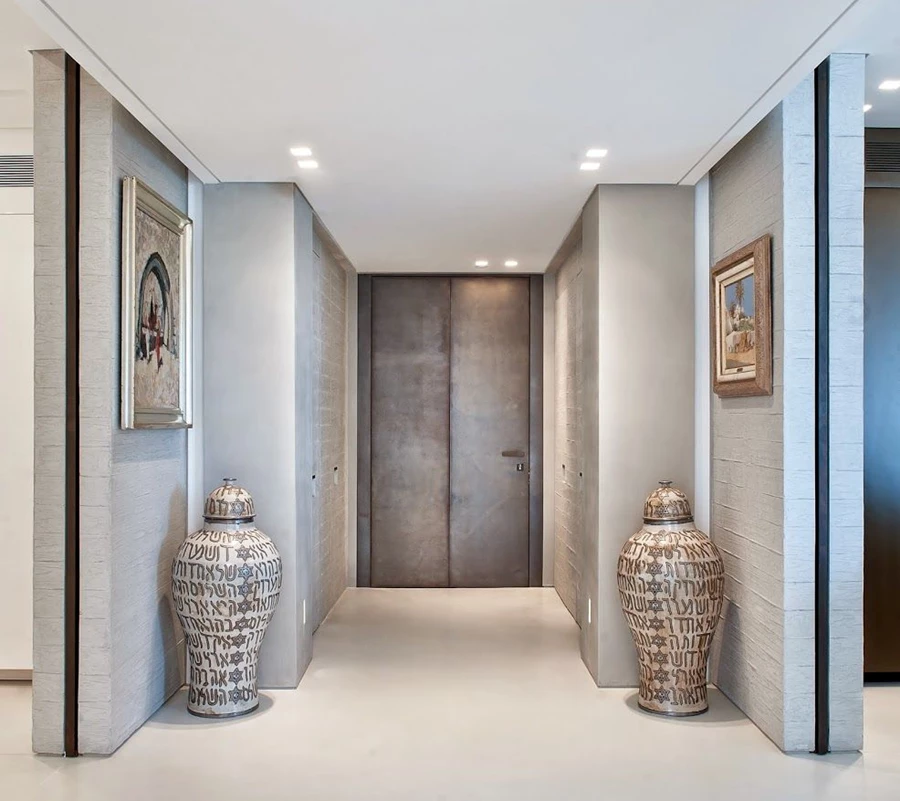 דלת כניסה עם מנעול חשמלי ממונע ומערכת אינטרקום, שיוצרה על ידי חברת נדב מגנזי בעבודת יד ובהתאמה אישית: שילוב בין פליז מושחם לבין חיפויי קיר במראה לבני בניה תעשייתיות, הכורך יחד מודרניזם עם סגנון עתיק, תוך שילוב עבר והווה, פונציונאליות ונוחות לצד אווירה מהפנטת