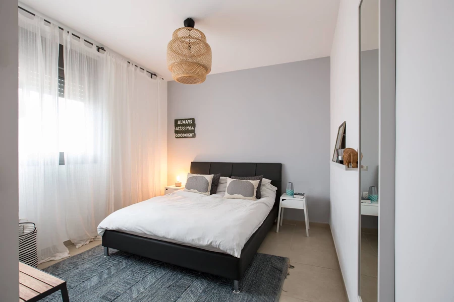 הקיר נצבע באפור על מנת להעניק קונטרסט לגב המיטה