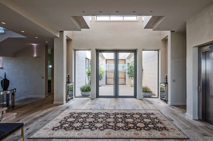 מבט מתוך חלל המגורים לחלל הביניים ולדלת האטומה העשויה עץ אלון מבוקע.