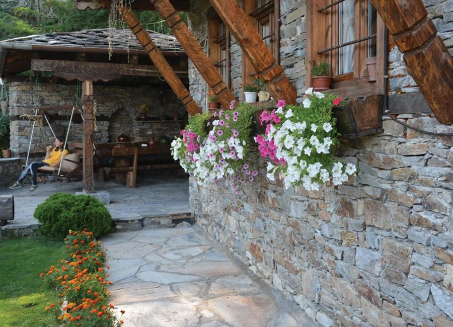 חזית הבית מקושטת בעציצים פורחים.