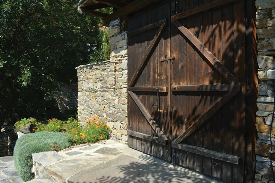 שערי עץ מאסיבים לפי מסורת הכפר גם בבניה החדשה.