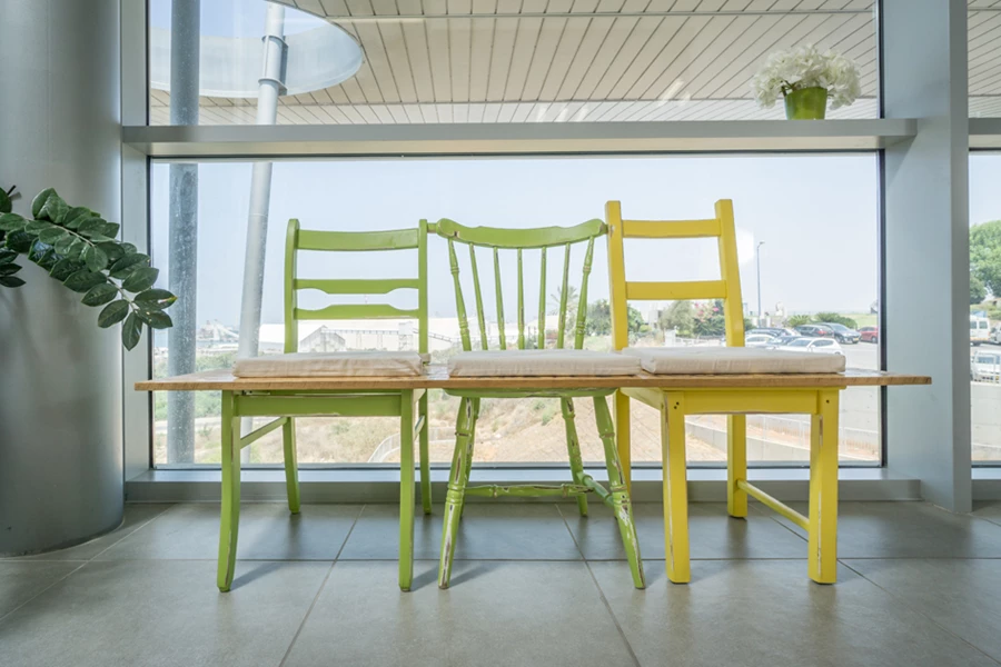 כיסאות עץ ישנים שנצבעו וחוברו לספסל באמצעות פלטת OSB