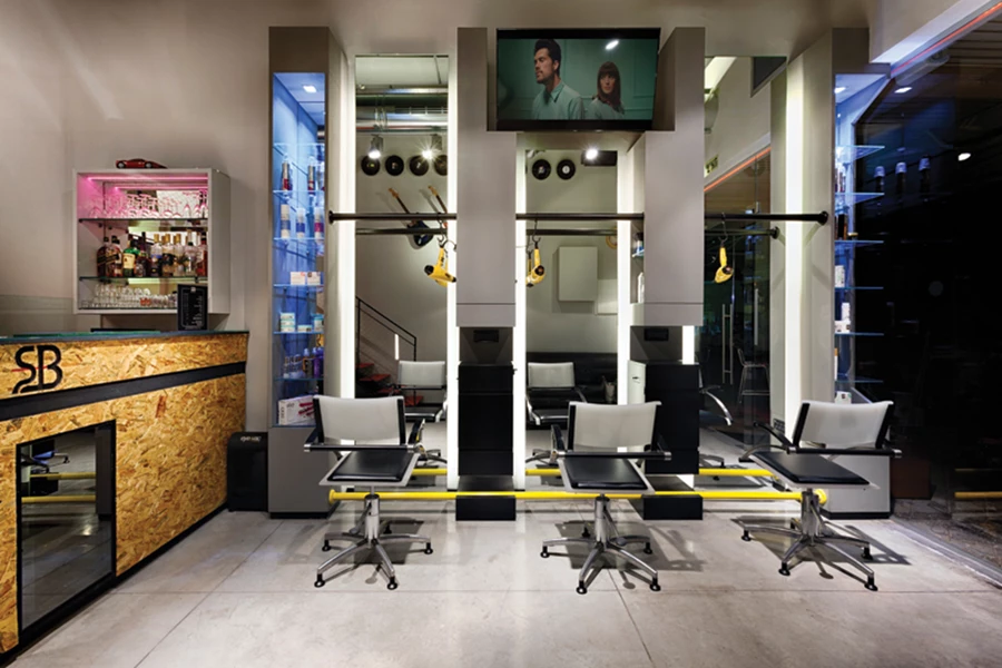 עמדות העבודה מול המראות: מייבשי שיער צהובים תלויים על צינור מתכת. מדפי זכוכית ומראות: קב