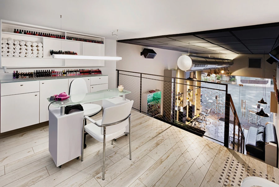 הגלריה העליונה: ניצול חלל גבוה שנחשף בעת השיפוץ לטובת מכון פדיקור-מניקור המעוצב כקופסה לבנה ההולמת את תכניו האסתטיים.