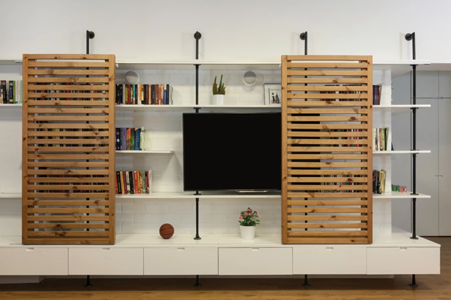 יחידת אי מרכזית משמשת לאחסון, אכילה ומולטימדיה, ועל הקיר תלוי אלמנט המהדהד את תריסי הספרייה: סרגלי עץ אופקיים שנתונים בתוך מסגרת ומשמשים לתליית כלים, עציצים, פתקים אישיים וכד