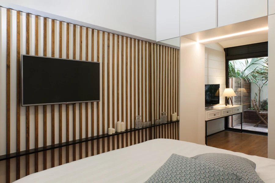 בקצה החלל, בהמשך לחדר השינה: חלל הסבה לאירוח ולעבודה מקושר לנוף הצמחייה באמצעות ויטרינת זכוכית.