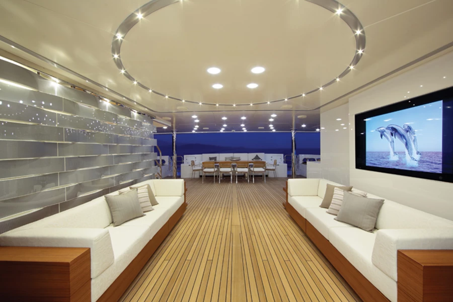 תיחום אזור אינטימי במרחב הסיפון באמצעות קיר עשוי טקסיליום ונירוסטה מטופלת 360 המתאימה לסביבה ימית. הקיר מעוצב כשתי וערב במופע גלי, ובתוכו משתלבת תאורת לד משובחת.