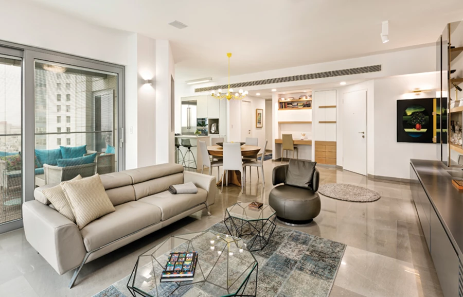 מבט מעומק החלל הציבורי שמרכז בשטחו את הפונקציות המשותפות כולל פינת עבודה, וכן שתי יציאות למרפסת המשקיפה אל הנוף. ריצוף באריחי מילנו גריי גדולים בליטוש מבריק וצבעוניות מאופקת של תתי גוונים. ריצוף: