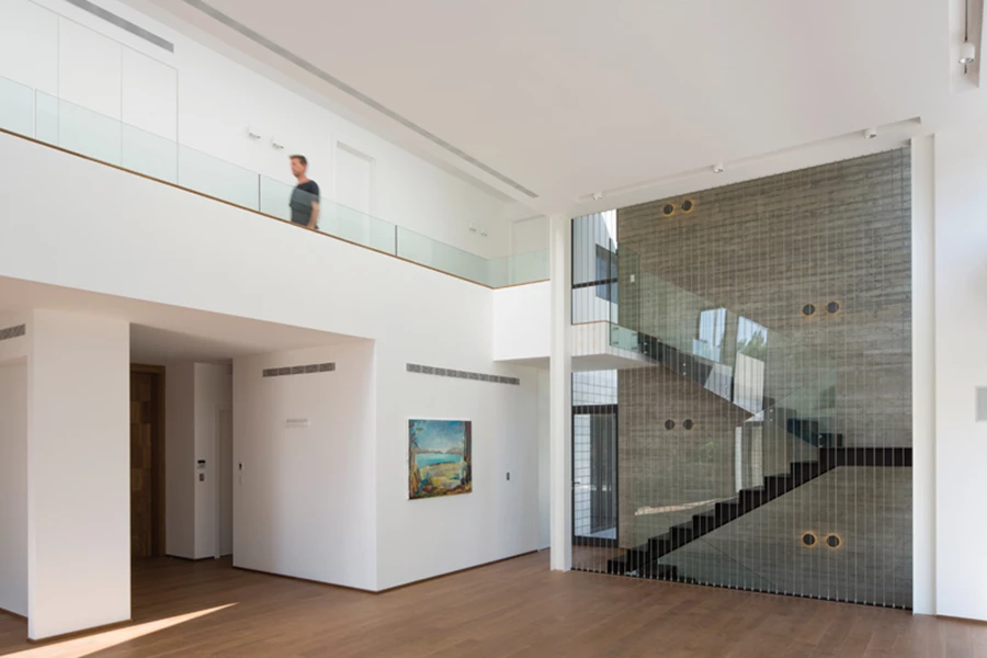 קיר בטון  תוחם את חלל המדרגות המובילות לקומה העליונה.