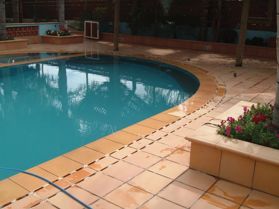 גווני האקווה של בריכת השחיה עם אריחי הטרה קוטה בגוון סלמון. | רוחמה שרון.