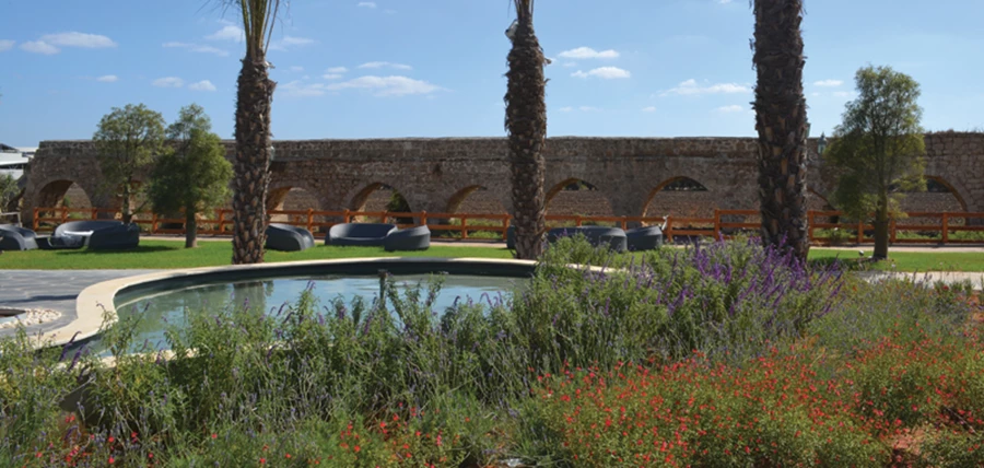 מרחבים ירוקים לאורך אמת מים עם פינות מנוחה מזמינות. אחוזת סנדרין.