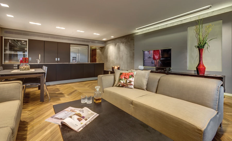 אזור הסלון בחלל הפתוח: שפת עיצוב חמימה משלבת ארומה קלאסית ומראה מודרני. ריצוף פרקט בדיגום אדרת דג, קירות בחיפוי טיח המדמה מראה בטון, ממד של ריחוף ותאורה שקועה ונסתרת המייצרת אפקטים שמעשירים את העיצוב.