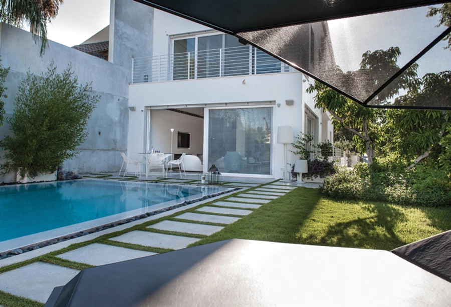 רחבת ישיבה עם מערכת גן מסוגננת, בריכה מפנקת, חלקת דשא תחומה בצמחייה מטופחת ועצים. ריהוט גן: