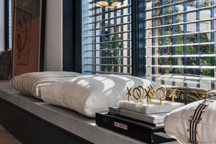 הספסל כאלמנט רב תכליתי המייצר אשליית קו ישר. פריטי נוי, כריות וטקסטיל: SETI.