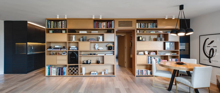 אלמנט ה-MDF במבט חזיתי: מכיל ספרייה וחללי אחסון שונים שתוכננו בקו אופקי כדי להסיט את העין מהמבנה האלכסוני של החלל ולמתן אותו. במרכזו ישנה כניסה לאזור החדרים, ואת שני עבריו תוחמות מחיצות עשויות סרגלים אופקיים מעץ אלון מושחר, שמנוגדות לו מבחינת חומר, טקסטורה וצבע, ואגב כך יוצקות עניין שונה ומאזן.