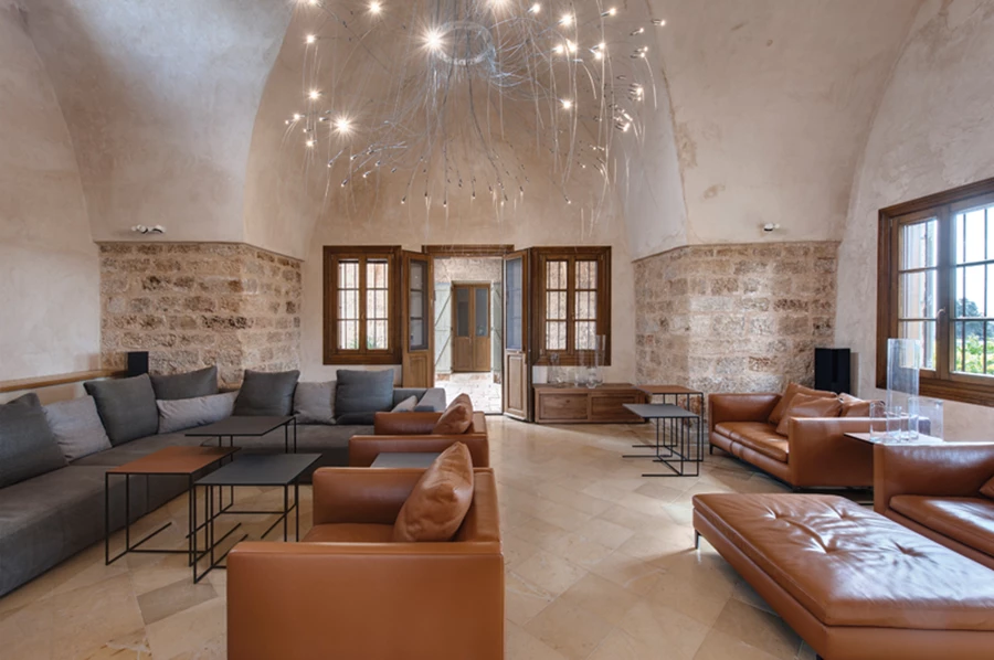 הסלון שמוקם באחד החללים הגדולים. פינות ישיבה בעיצוב נקי-מסוגנן מזמינות הסבה  נינוחה בצוותא.  חיפוי טיח במיקומים שלא ניתן היה לשקם את חיפוי הכורכר המקורי.