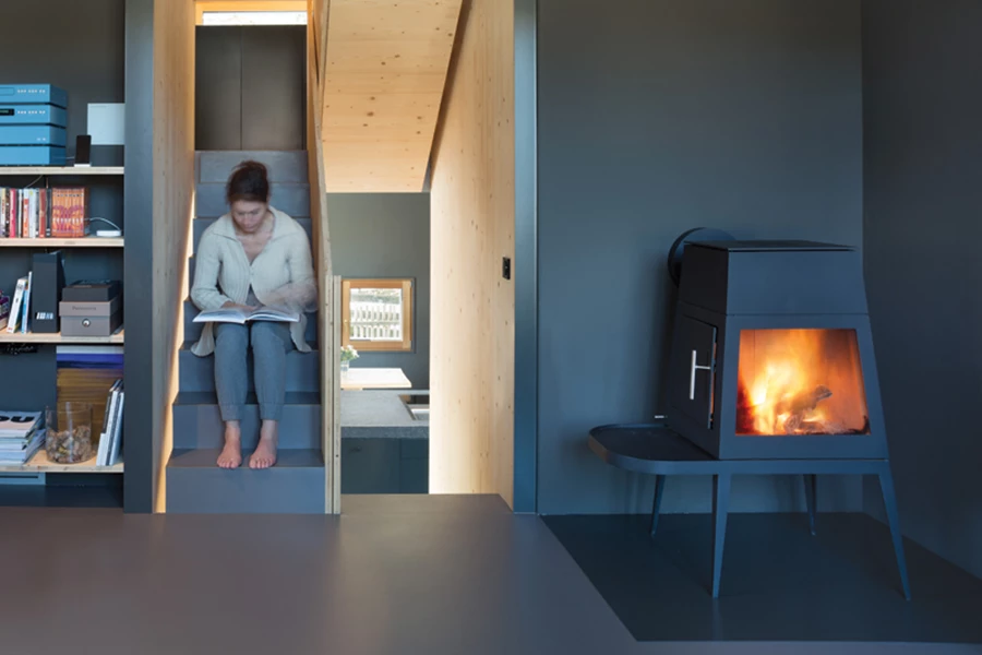 מפלס המגורים חמים וביתי, עם קמין עצים וספרייה קטנה.
