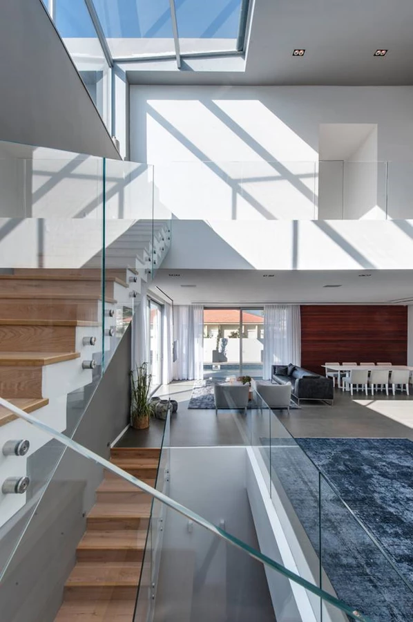 גרם המדרגות שבחלל הציבורי: צמוד לקיר בטון ונתמך על ידו, ומשלב מדרכי עץ אלון ומעקה שקוף. פתח גדול שנפרץ בקיר מחדיר פנימה אור יום נעים.