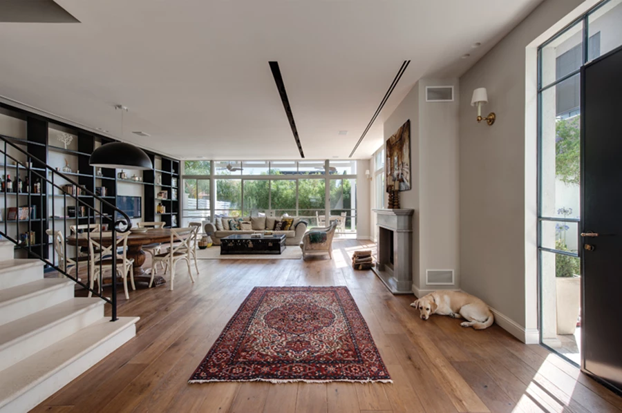 אזורי האירוח שבחלל הציבורי: מראה כפרי-חמים ואוורירי כאחד. ריצוף פרקט אלון מגוון, קירות בגון חאקי רך, ופתחים גדולים במסגרות פרופיל בלגי בגון שמנת עם חלוקות אופקיות ואנכיות לתוספת עניין.