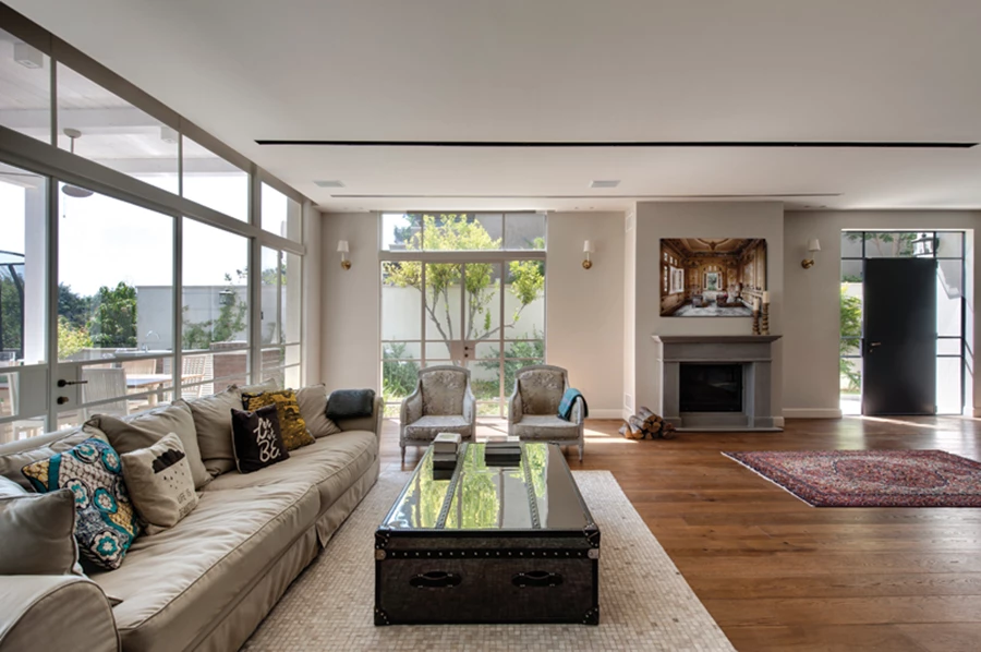 פתחים גדולים מאצילים פתיחות אוורירית, פריטי ריהוט אקלקטיים, תאורה מגוונת משלבת גופים שקועים וצמודי קיר ברוח הסגנון הכפרי, וקמין עצים מחופה אבן אפורה.