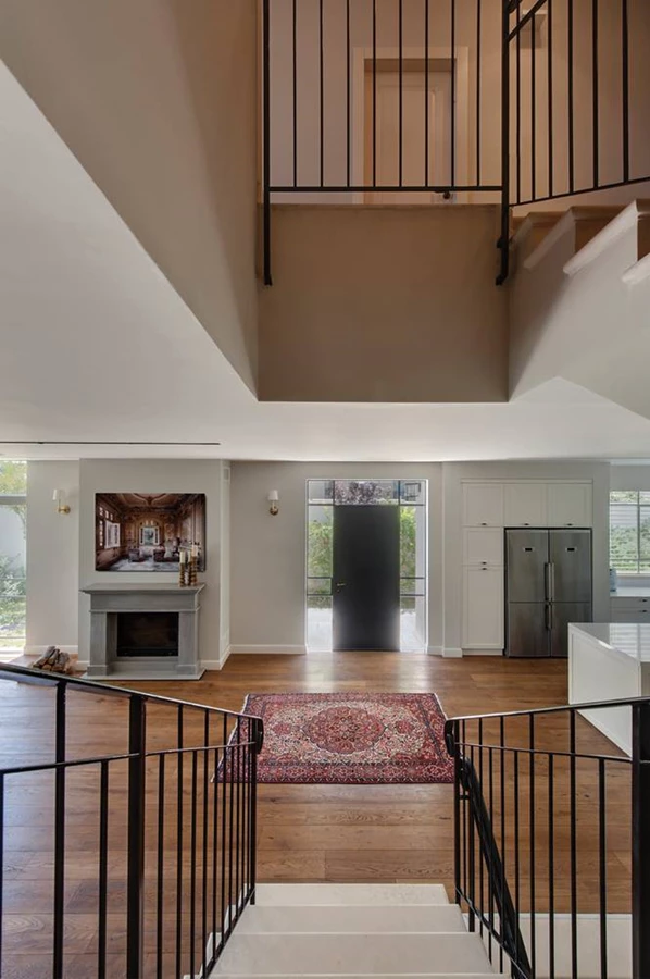 גרם המדרגות הממוקם מול דלת הכניסה כנקודת אמצע החוצה את חלל הקומה לשני אזורים מוגדרים מחד, אך פתוחים זה כלפי לזה מאידך.  מעקה הברזל השחור מתכתב עם דלת הכניסה העשויה פרופיל בלגי שחור ותחומה במסגרת זכוכית שקופה המחדירה לחלל אור ממזרח לדרום.