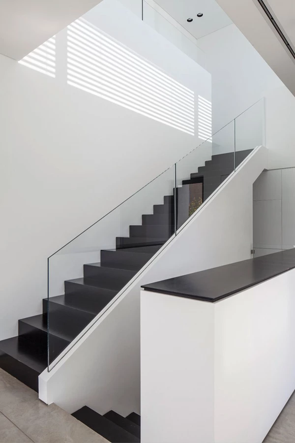 חלל המדרגות: מדרגות ברזל שחורות, מעקה שקוף, וקרני שמש החודרות מבעד פתח בחלקו העליון משרטטות דיגומים גראפיים על הקירות והרצפה. ריצוף הקומה בוצע בבטון מוחלק וקירותיה לבנים.