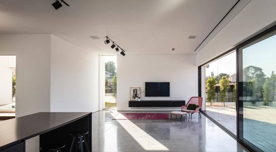 איזור הסלון שבחלל המגורים: שקיפות, מינימליזם וקשר הדוק עם החוץ.  תאורה: