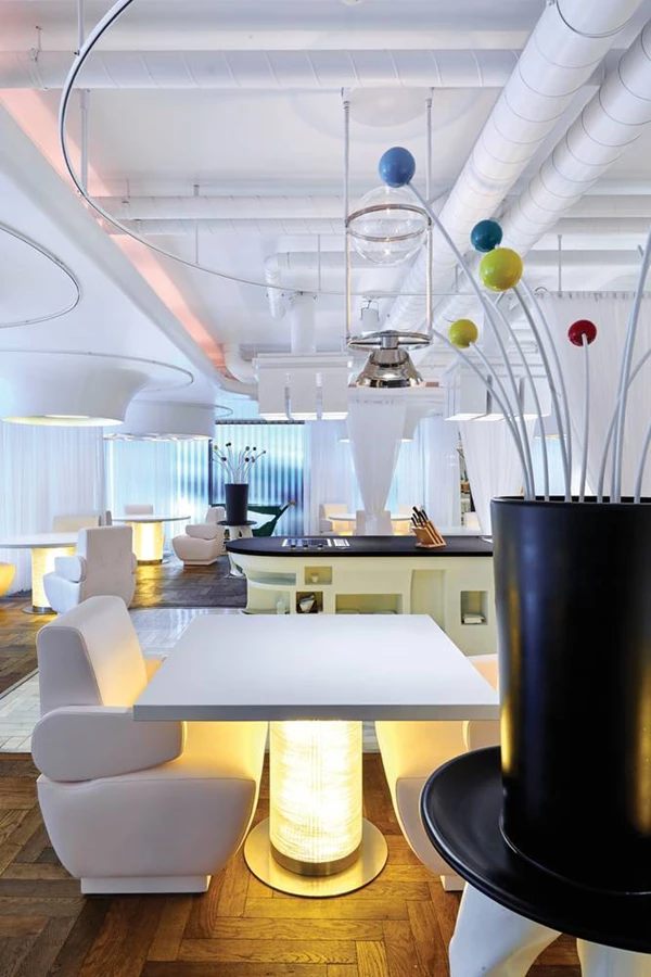 הישיבה במסעדה: כורסאות עור ורודות במקום כיסאות, ושולחנות בגדלים שונים מעוצבים כשילוב של משטחי סיילסטון לבנים וצחים במיוחד עם בסיס מעוגל מפיברגלס המפיץ אור תחתי.