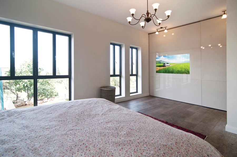 ארון בעל חזית זכוכית בה משתלב מסך טלויזיה כמישור אחד ססמי | פיתוח ישראלי מבית הרדור ארונות הזזה.