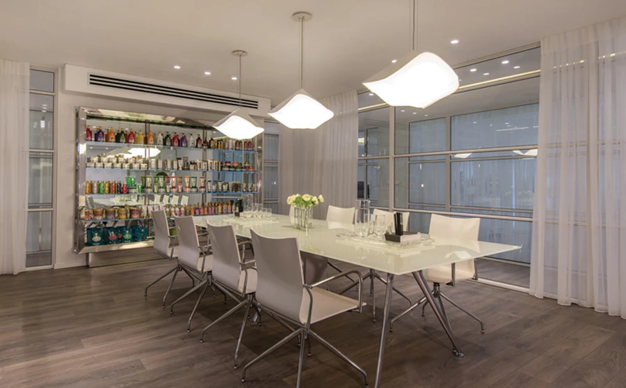 חדר הישיבות: שולחן וכיסאות בקווי עיצוב נקיים, גופי תאורה דקורטיביים, ויחידת תצוגה שעוצבה ייעודית כמדפים המשתלבים בתוך מסגרת נירוסטה עם חיתוך פזה. שולחן וכסאות:״פיטרו״.