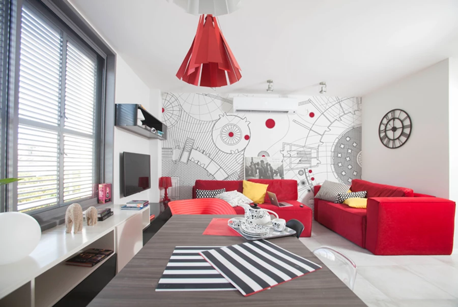 החלל הציבורי בקומת הכניסה לאחר השיפוץ:  חזות צעירה ורעננה, משובצת בנגיעות אדומות. ריצוף באריחי גרניט פורצלן המדמים מראה בטון,  תאורת ספוטים מתכווננים, וטפט בדיגום גראפי שנוצר ייעודית ומחפה את כל קיר הסלון כמוקד דומיננטי עם קריצה.