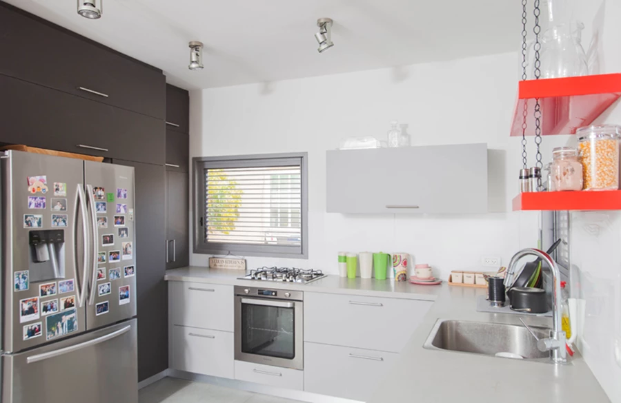 גרם המדרגות ששודרג: קונסטרוקציית המתכת נצבעה באפור כמרכיב של שפת הצבע בחלל, המעקה הוחלף במעקה ברזל בעיצוב אופקי, והטפט הגראפי שמחפה את הקיר התוחם אותו ו