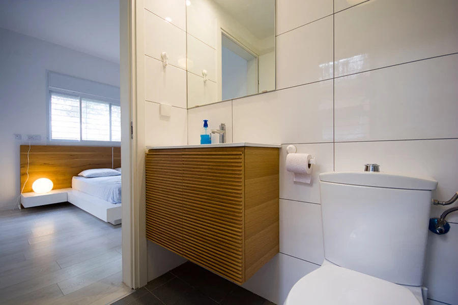 מוטיבים של עץ המוסיף חמימות חוזרים בחדר הרחצה ובחדר השינה של ההורים.