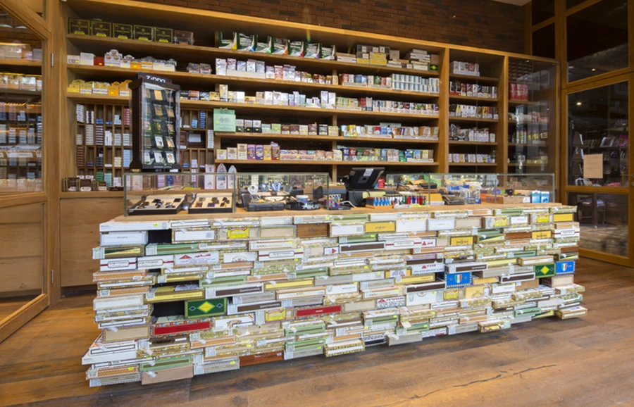 דלפק הקבלה מחופה כולו קופסאות סיגרים מיוחדות מהסיגרים הנמכרים במקום.