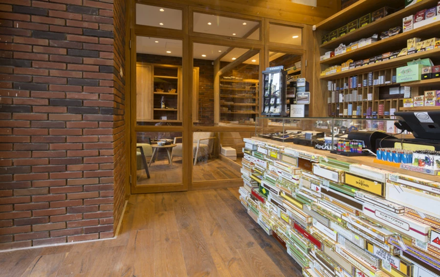 דלפק הקבלה גובל בחדר העישון הצופה אל רחבת הכניסה. חיפויי קירות: בריקים במראה מתועש בגווני אדום-שחור ״קרן סטון״.