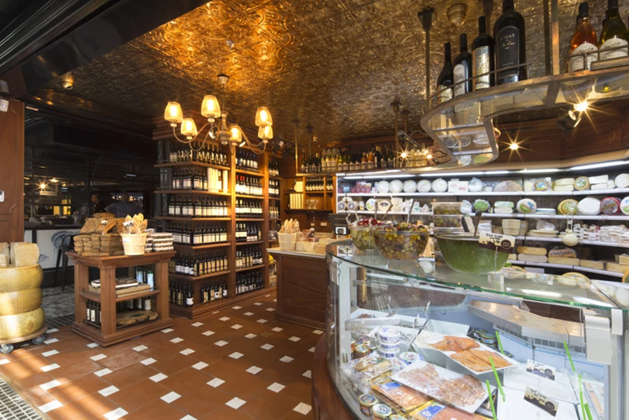 כתר פליז מעל למקרר הגבינות, תקרה דקורטיבת, ריצוף טרה קוטה, גופי תאורה ופרטי נגרות- הכל בהתאמה אישית.