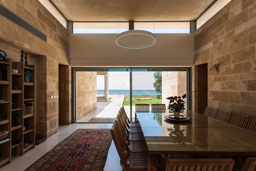 חיפוי אבן הכורכר משמר קו אופקי המעצים את תחושת המרחב והזרימה הפתוחה, ריצוף בטון לבן מוחלק, גג מרחף מבטון לבן גלוי נוטה מעט מעלה, ותאורה המתבססת על גופים צמודי קיר ופסי תאורה שאינם נוטלים מנפחו של החלל. אף הריהוט המסווג כריהוט גן/חוץ מגלם את נרטיב ה