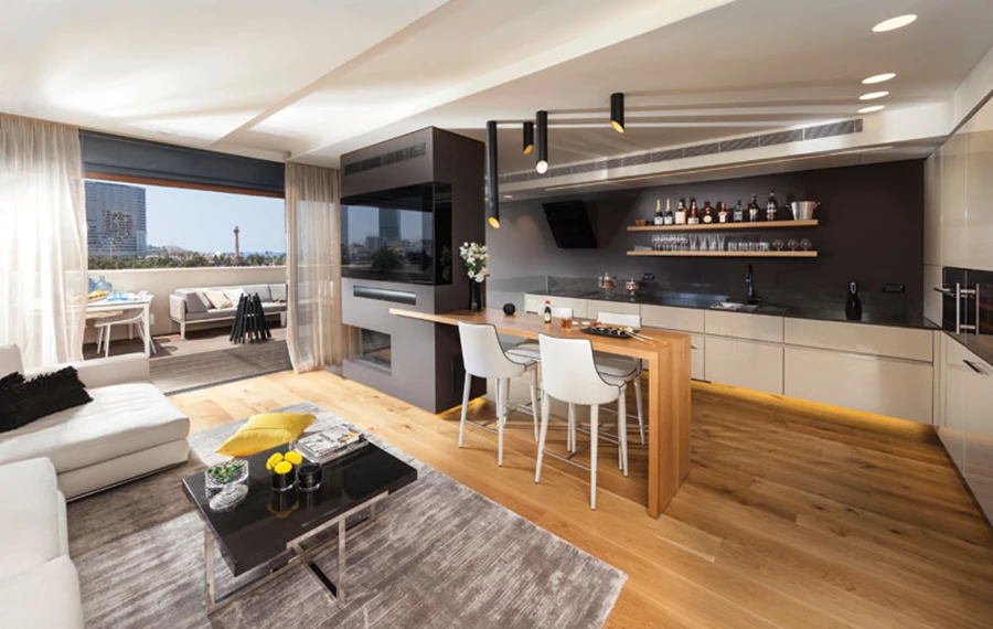 יחידה דו צדדית מרחפת משרתת את אזורי הסלון והמטבח ומכילה גם קמין, ודלפק אכילה ה