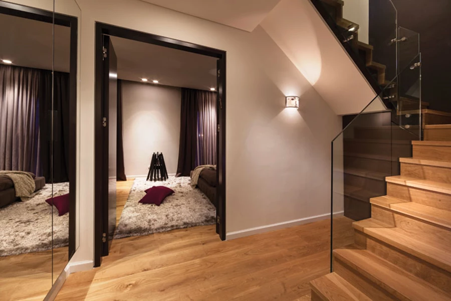 גרם המדרגות שתוכנן מחדש ומבואת החדרים בקומה התחתונה: החלל שמתחת גרם המדרגות מנוצל לצרכי אחסון, שירות (מכונת כביסה ומייבש) ותקשורת. ארון חשמל המכיל את תשתיות החשמל החכם משודרג באמצעות דלתות מראה מרחפות שאף מקנות אשליית גודל. חשמל חכם: