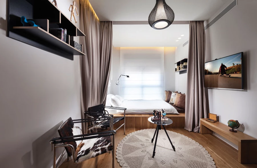 חדרו של הבן: מיטה בנויה כבמת עץ רחבה, ווילונות ש