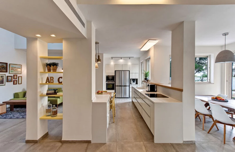 מרחב הקומה לאחר פרישת החלל החדשה: המטבח ממוקם במרכז, חובר לפינת המשפחה ומקושר באמצעות יחידה נמוכה לפינת האוכל, והסלון ממוקם מעברו השני. ריצוף באריחי גרניט פורצלן דמוי בטון, ופתחים גדולים המקשרים את החלל לגינה. ריצוף: