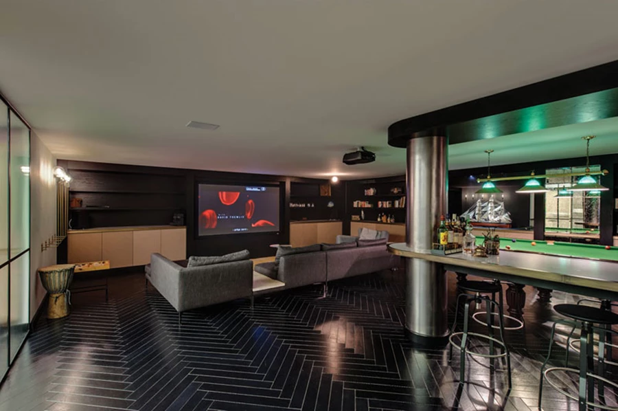 עיצוב דרמטי בקומת המרתף המשמשת כקומת בילוי פנאי ומשלבת בשטחה אזור קולנוע, שולחן ביליארד, אזור בר כמרחב פתוח ואזור כושר המופרד באמצעות מחיצת פרופיל בלגי שחור עם זכוכית במרקם פסים.  ריצוף בפרקט שחור בדיגום אדרת דג, נגרות אלון פרח שחור עם שילוב פליז ואלון חוטים בגימור טבעי. הגון השחור השולט בעיצוב קומת המרתף