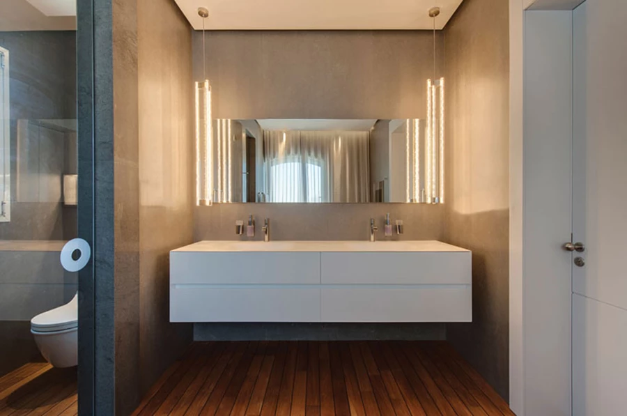 חדר הרחצה של יחידת המאסטר: שימוש עשיר ומובחר של חומרים. ריצוף עץ עם הפרדות גומי שחורות בדומה לזה המשמש בסיפוני יכטות, משקופים וספים עשויים בזלטינה כהה, חיפוי הקיר בקרליט (גרניט פורצלו דק) אפור, אביזרים סניטאריים מסוגננים ואביזרים משלימים מפנקים. כלים סניטריים וחיפויים: חזי בנק.