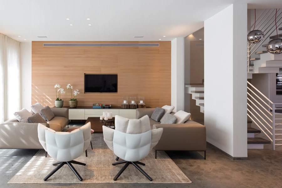 הסלון: פינת ישיבה חמימה בקווים קלאסיים וגוונים טבעיים, חיפוי עץ בקיר בו משתלב מסך הטלוויזיה, תאורה שקועה שמאפשרת ליצור תרחישי אור משתנים ווילונות רכים. שולחן האוכל הגדול עשוי עץ עם רגליים מסיביות בסגנון אבירים. תאורה: