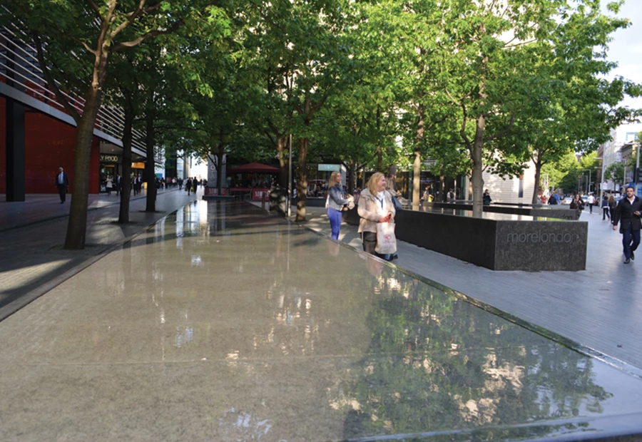 כניסה אל אחד ממרכזי הקניה-מראה מרענן של מים בהם משתקפים ענפי העצים והשמים.