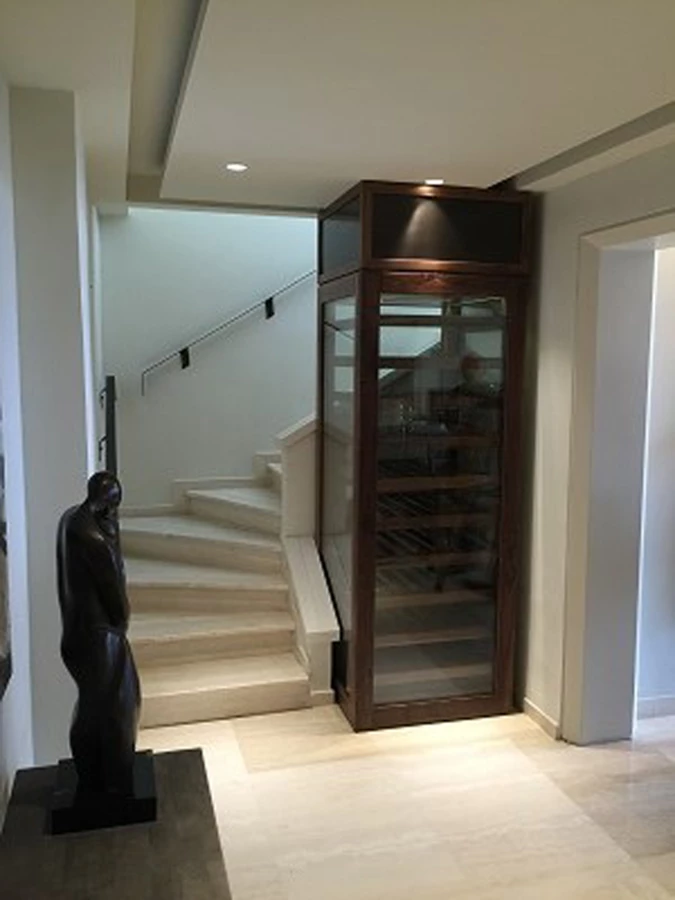 מקרר יין בהתאמה לחלל המדרגות, עץ אגוז בשילוב פליז מושחר. אדריכלות: מיכאל אזולאי