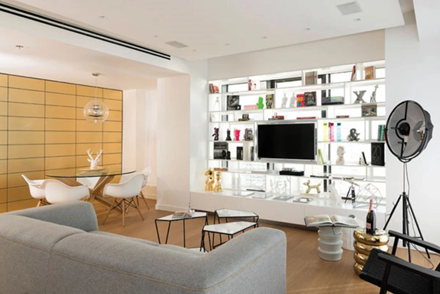 בחלל הפנים: קיר מחופה אריחים זהובים מהדהד את האלמנט הזהוב של המעטפת. הספרייה שלצדו תוכננה ייעודית עם מדפים דקיקים במיוחד, כשמבעד המרווחים הגדולים ביניהם מבצבץ נוף הים.